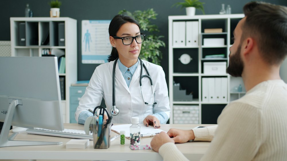 A clinician in consultation with a male patient